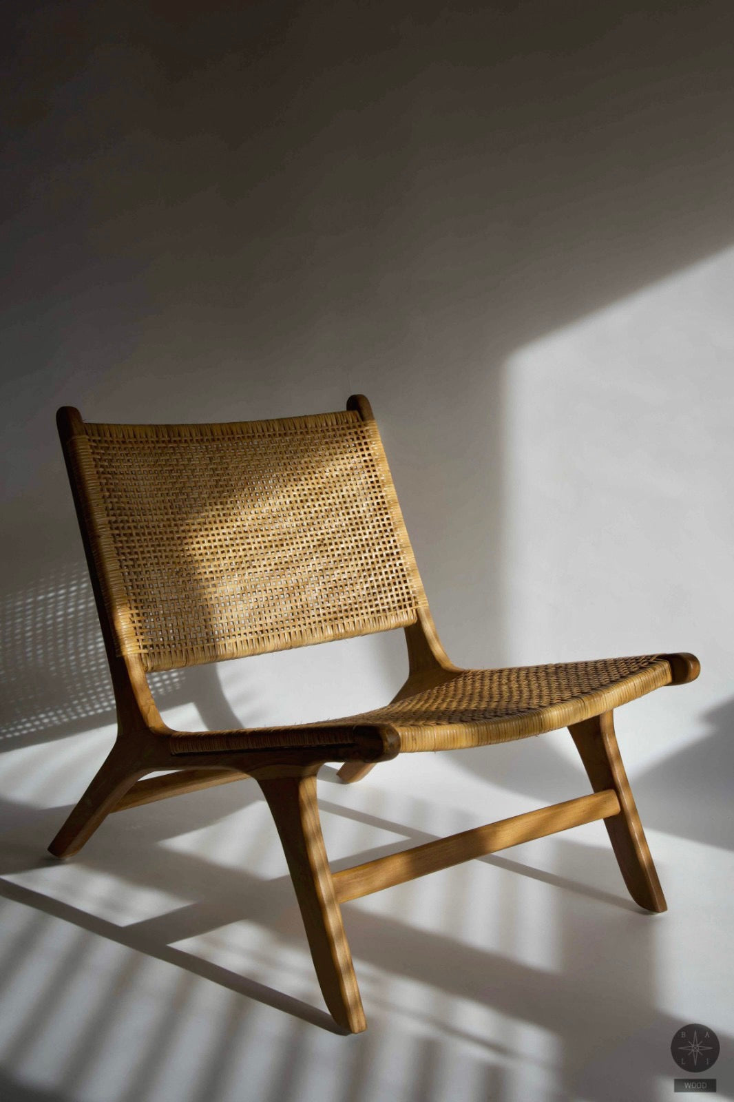 Low chair made of teak wood and natural rattan