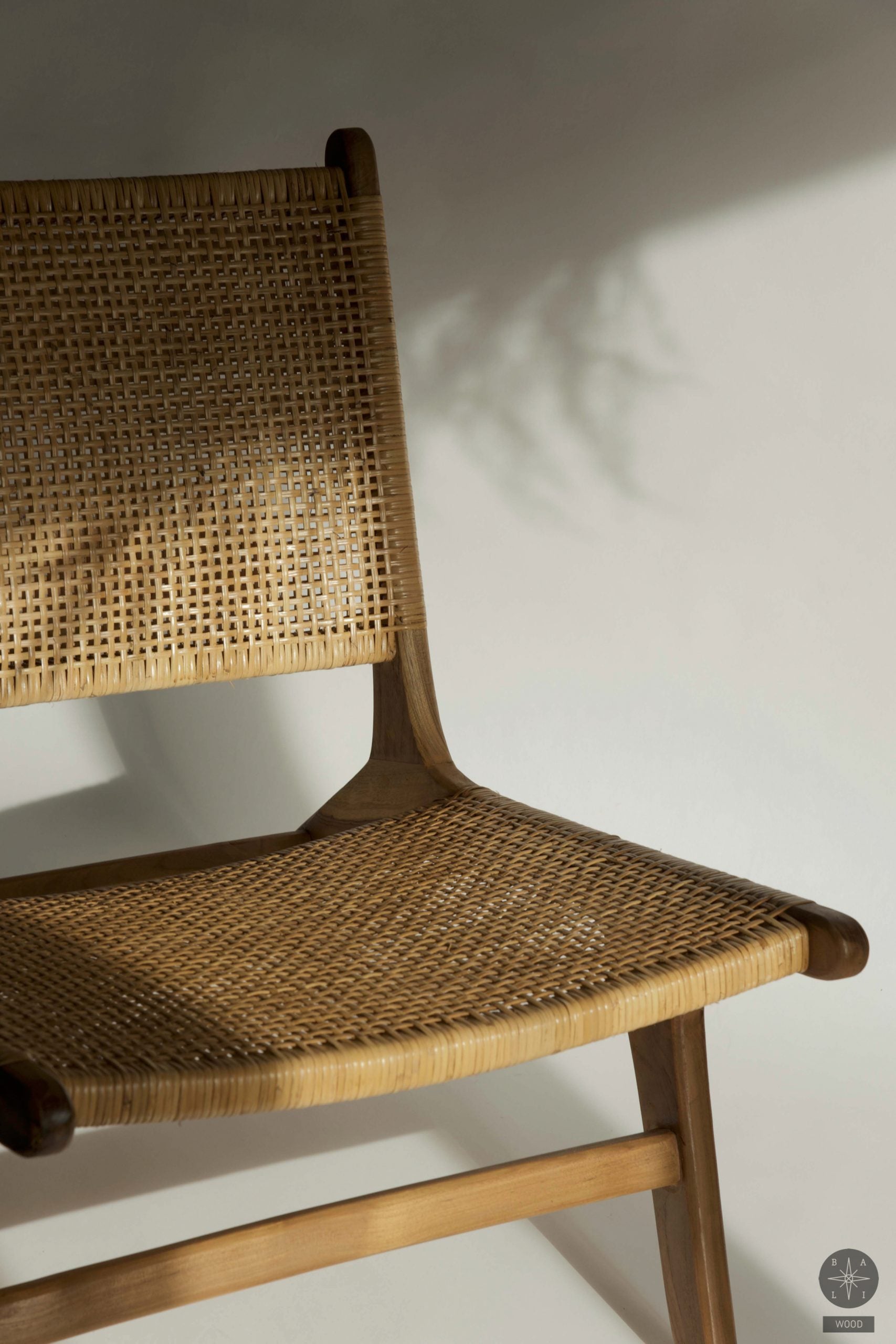Low chair made of teak wood and natural rattan