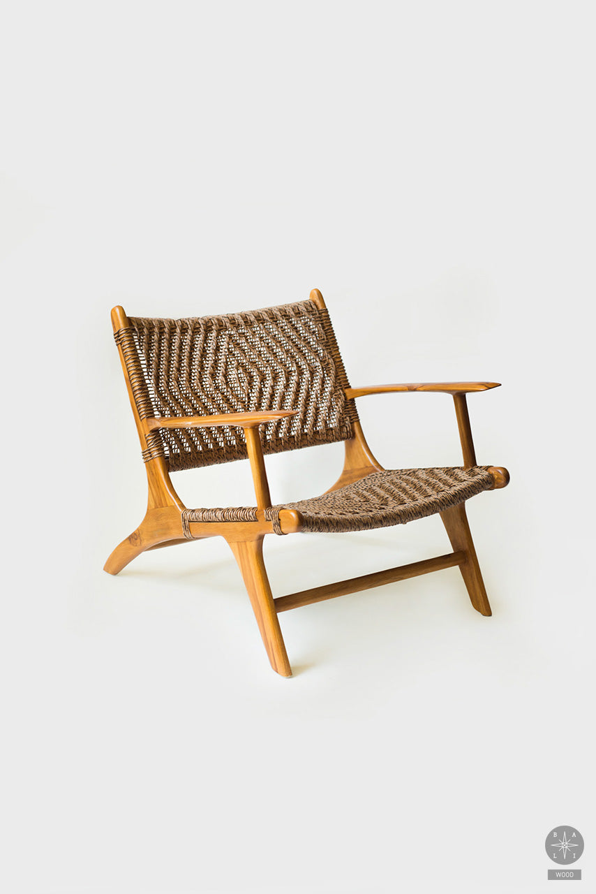 Low chair made of synthetic rattan with armrests